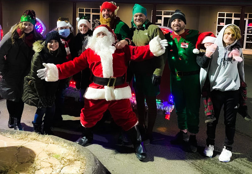 Santa delivering holiday gifts to a West Haven family